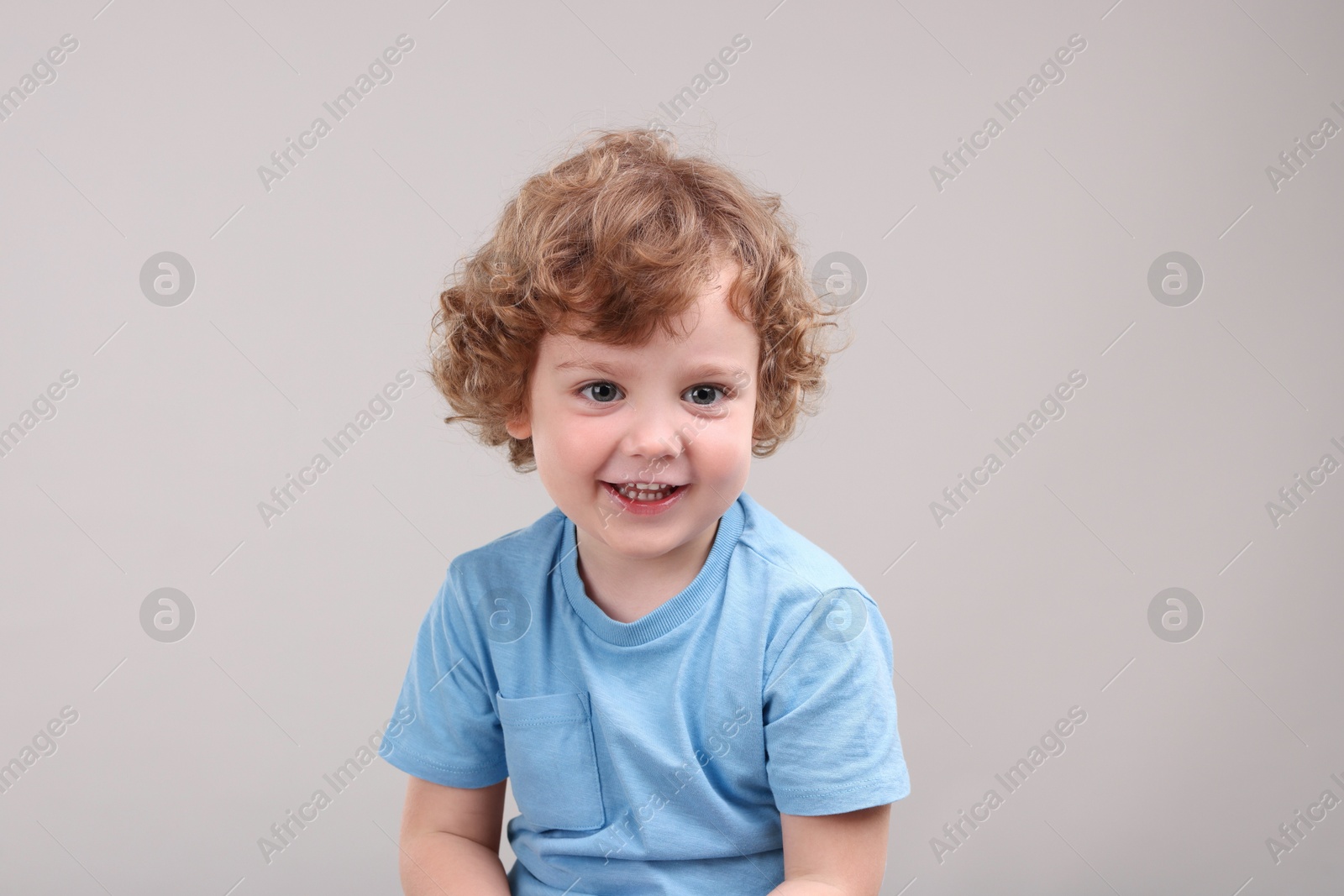 Photo of Portrait of cute little boy on grey background