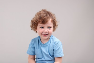 Photo of Portrait of cute little boy on grey background