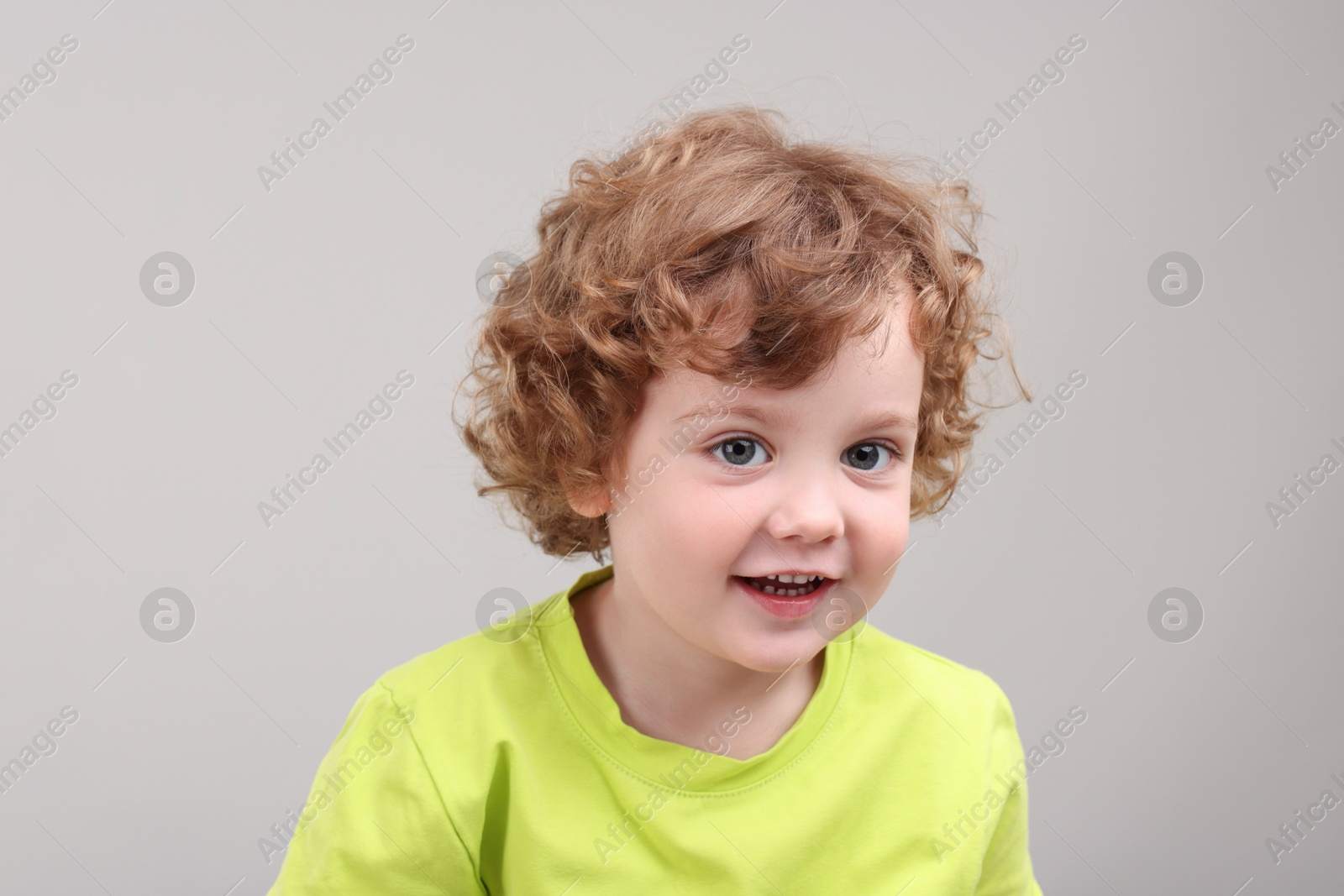 Photo of Portrait of cute little boy on grey background