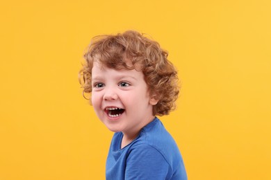 Photo of Portrait of emotional little boy on yellow background