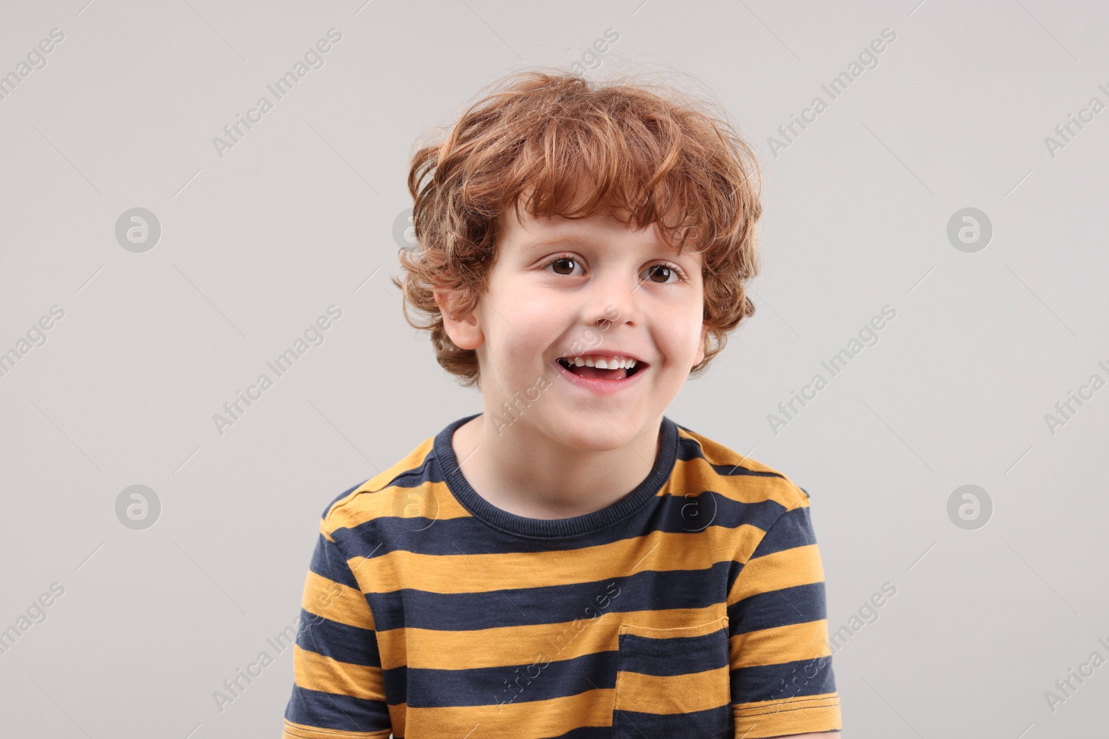 Photo of Portrait of cute little boy on grey background