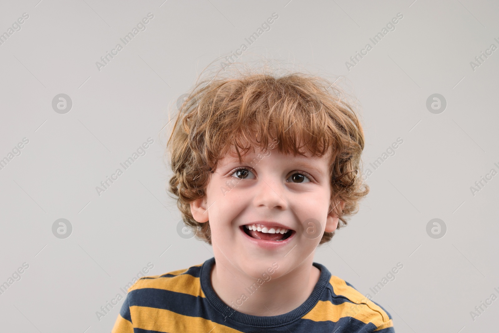 Photo of Portrait of cute little boy on grey background