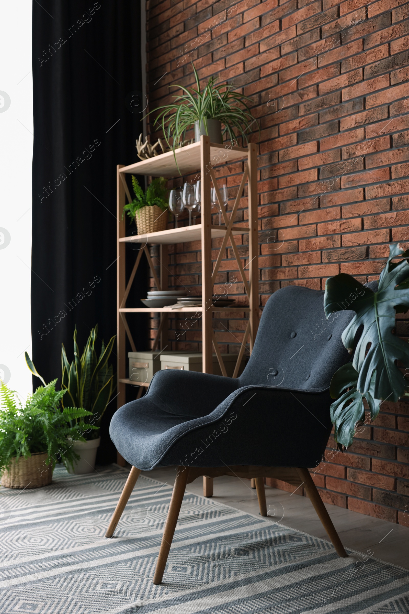 Photo of Shelving unit, green houseplants, armchair and elegant curtain in room. Interior design