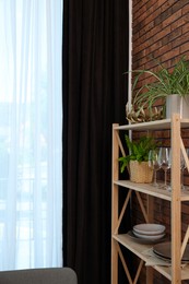 Shelving unit and elegant curtain in room. Interior design