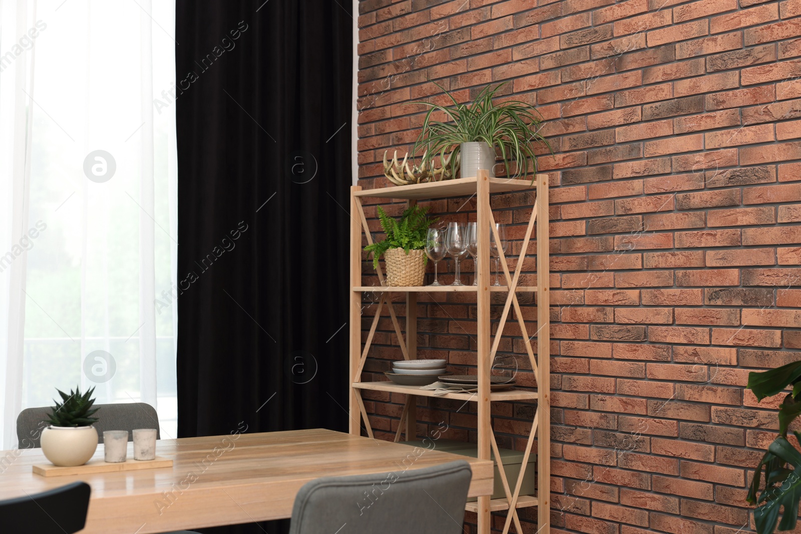 Photo of Shelving unit, table, chairs, green houseplants and elegant curtain in room. Interior design