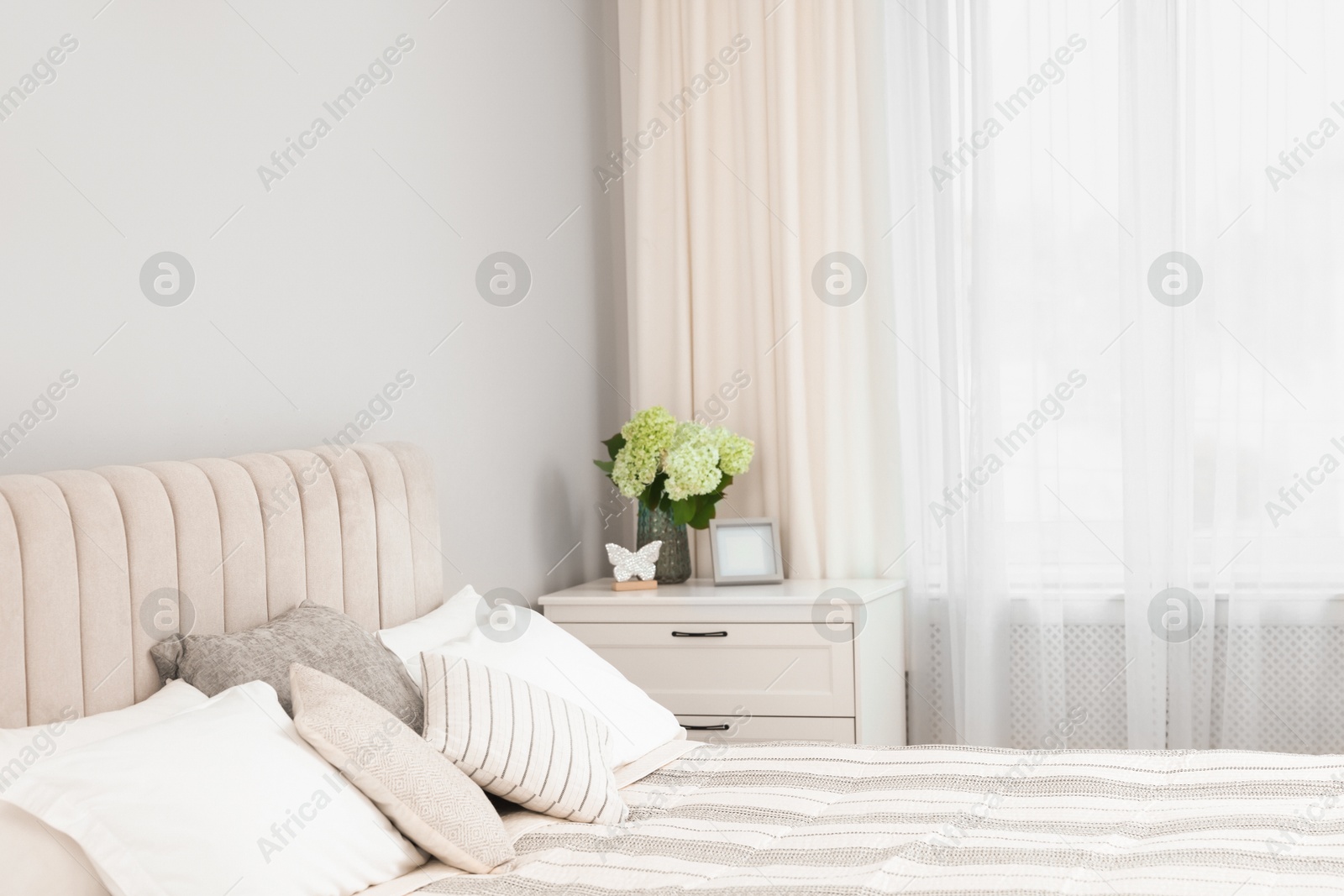 Photo of Large bed, chest of drawers and window with curtains in bedroom, space for text. Interior design