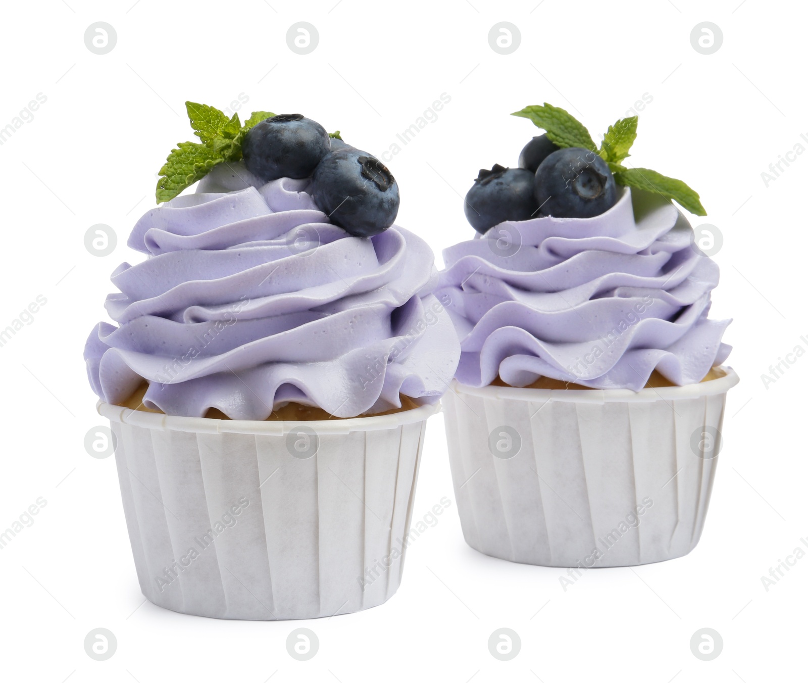 Photo of Tasty cupcakes with blueberries and mint isolated on white