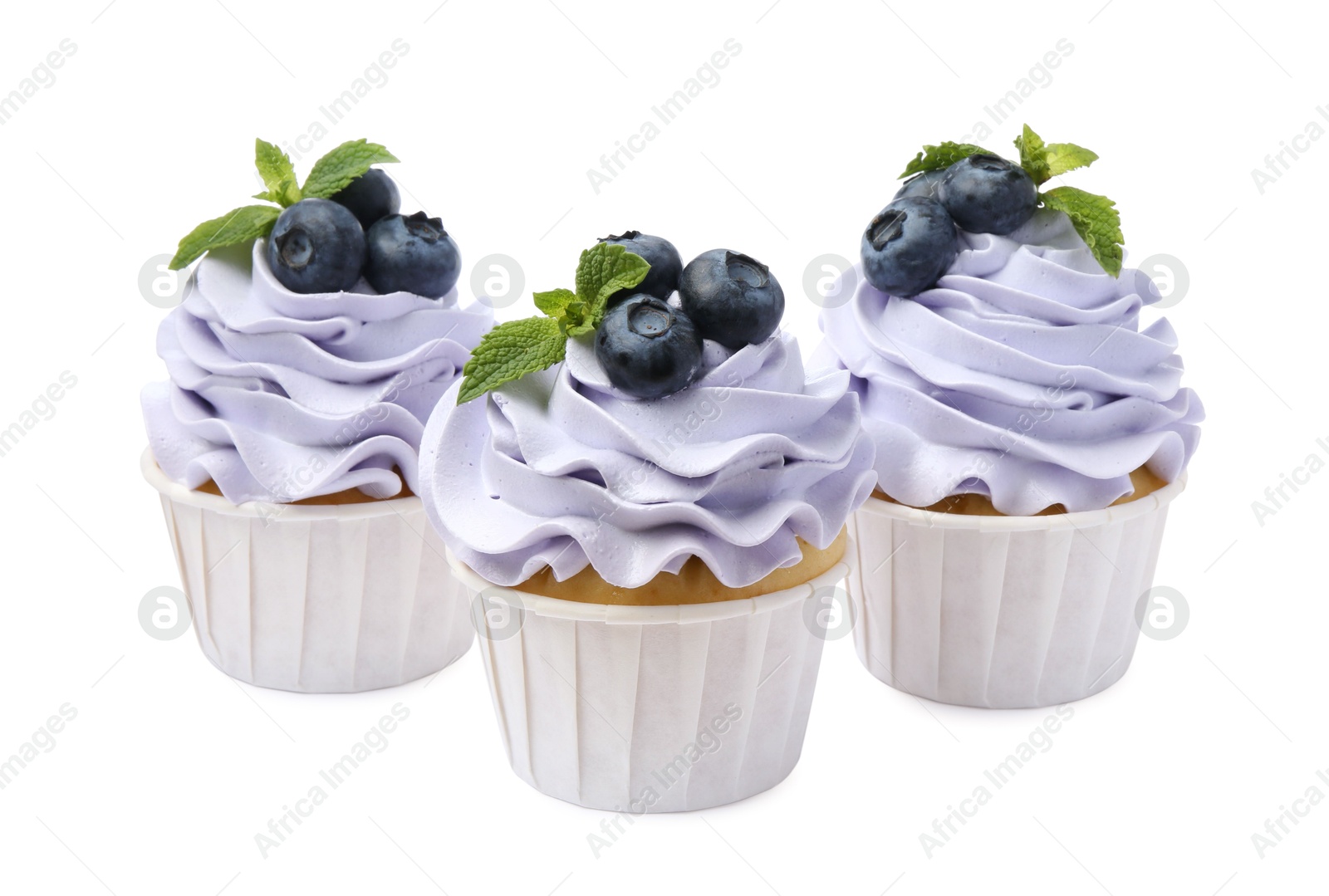 Photo of Tasty cupcakes with blueberries and mint isolated on white