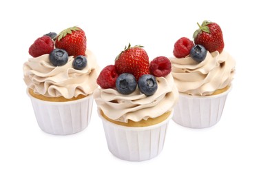 Photo of Tasty cupcakes with different berries isolated on white