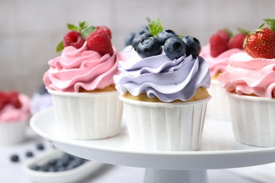 Photo of Tasty cupcakes with different berries on table, closeup