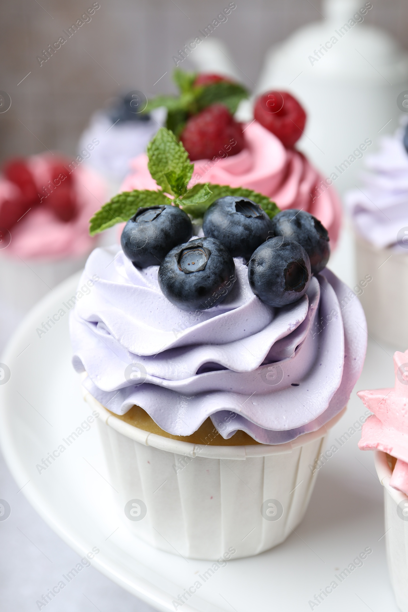 Photo of Tasty cupcakes with different berries on table, closeup