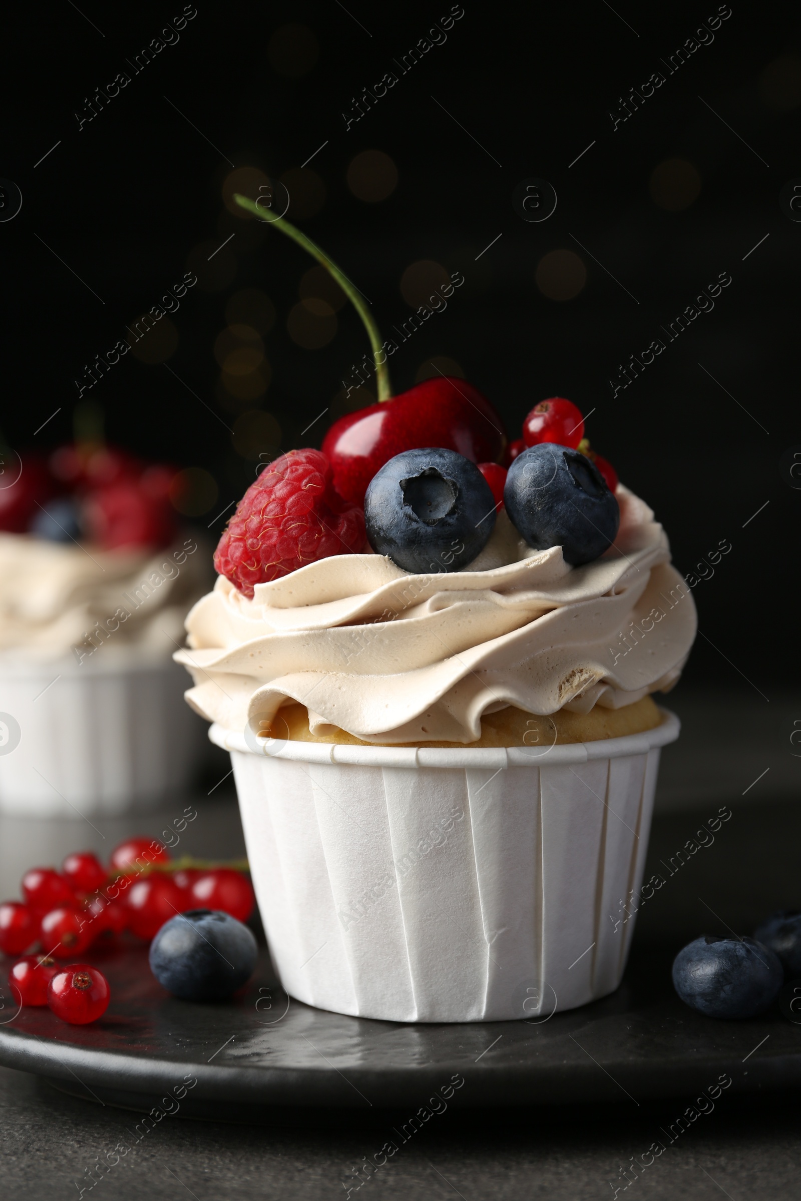 Photo of Tasty cupcake with different berries on grey table, closeup