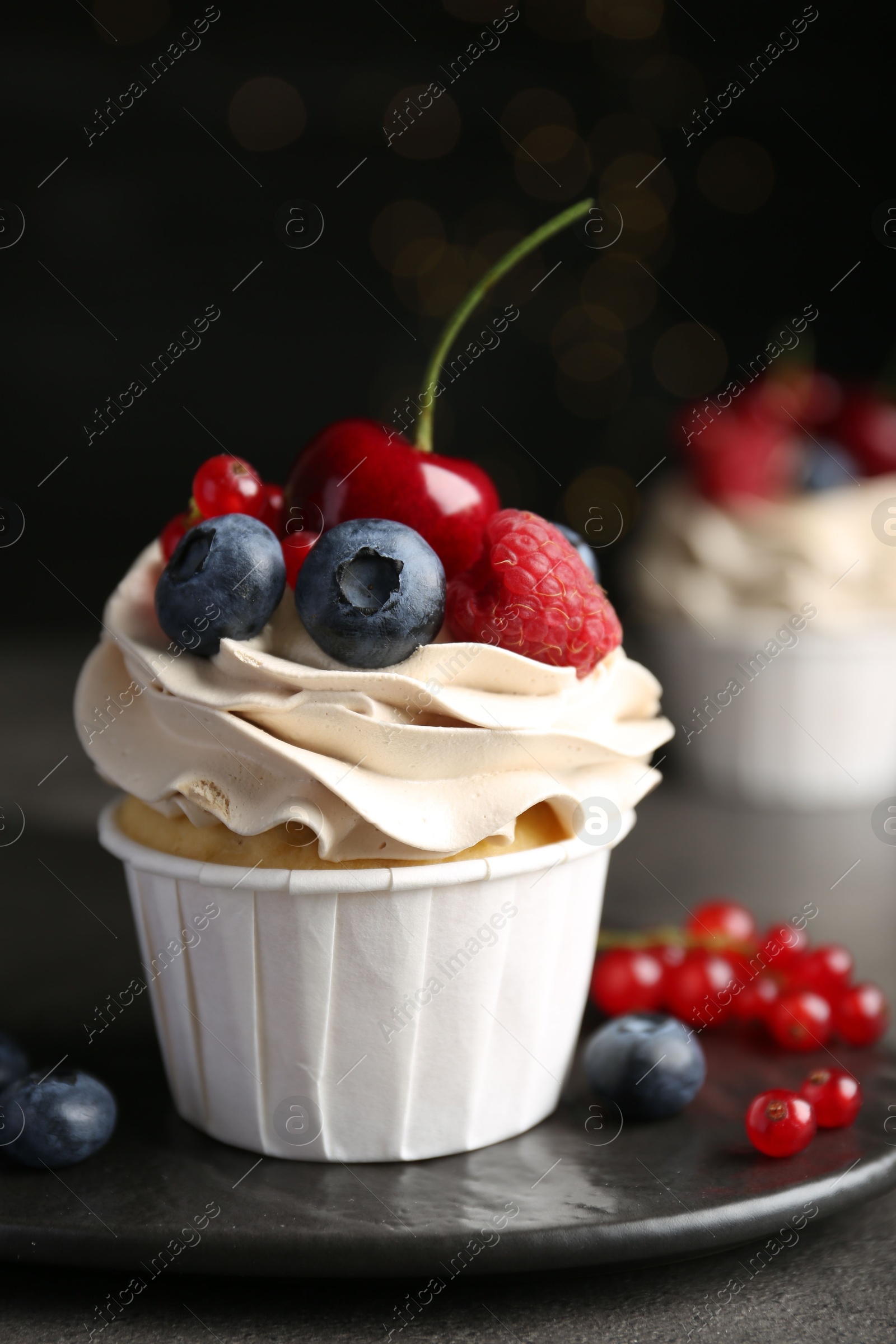 Photo of Tasty cupcake with different berries on grey table, closeup