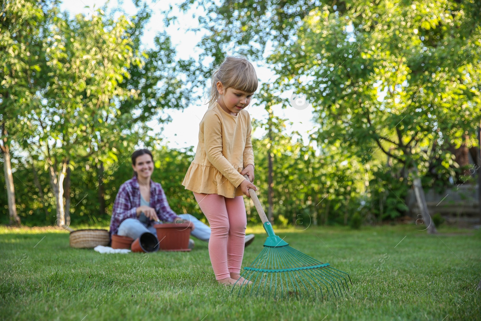 Photo of Mother and her daughter working together in garden