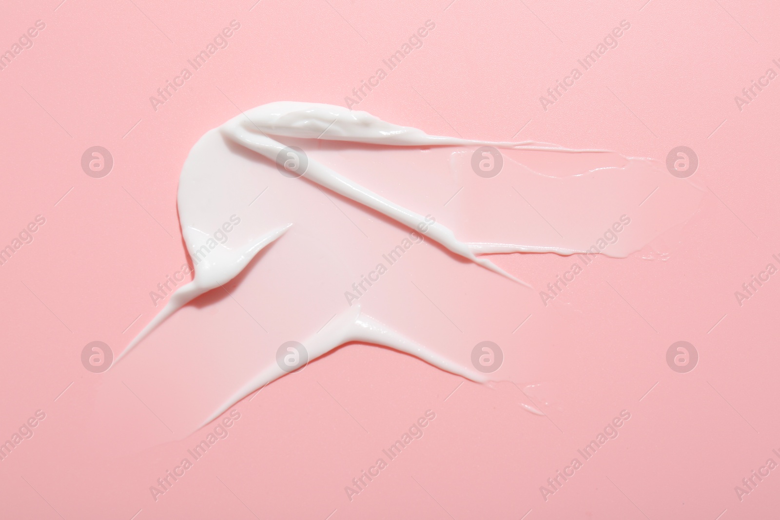 Photo of Sample of face cream on pink background, top view