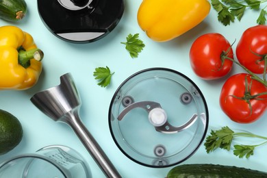 Photo of Hand blender kit and fresh products on light blue background, flat lay