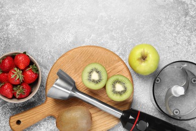 Photo of Hand blender kit and fresh fruits on grey table, flat lay