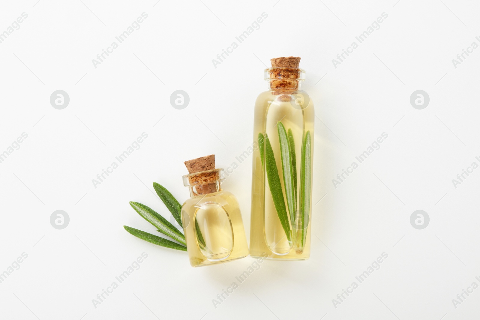 Photo of Bottles of rosemary essential oil on white background, flat lay