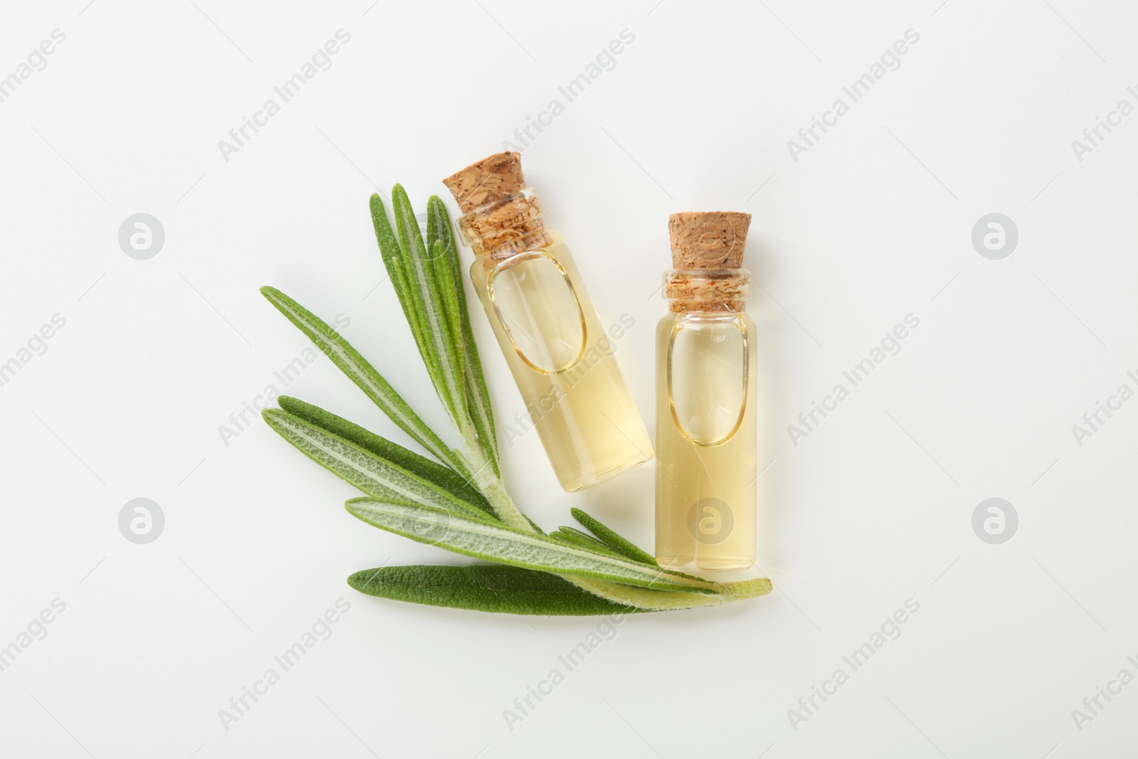 Photo of Bottles of essential oil and fresh rosemary on white background, flat lay