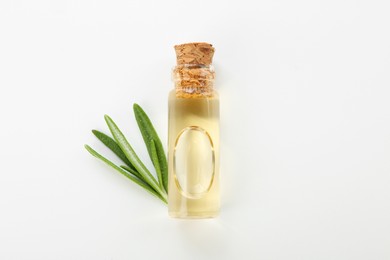 Photo of Bottle of essential oil and fresh rosemary on white background, flat lay