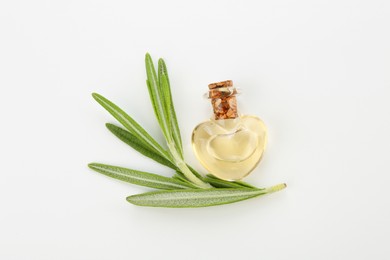 Bottle of essential oil and fresh rosemary on white background, flat lay