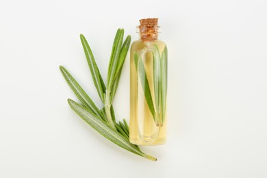 Photo of Bottle of essential oil and fresh rosemary on white background, flat lay