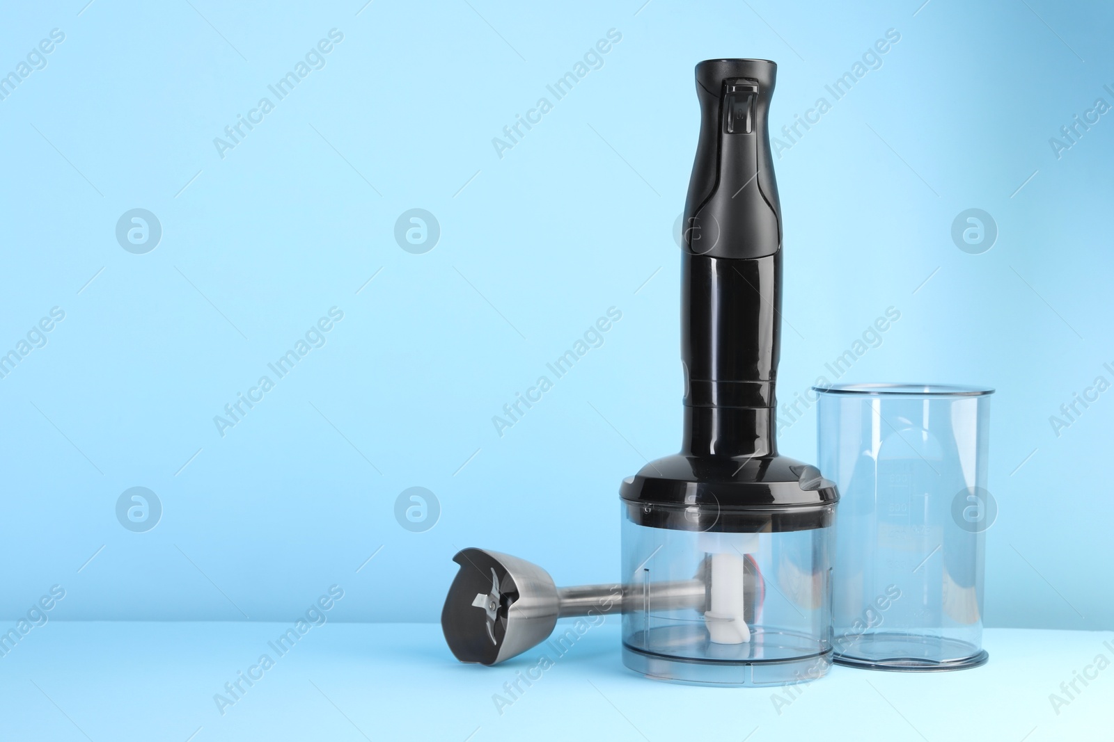 Photo of Hand blender kit on light blue background, space for text