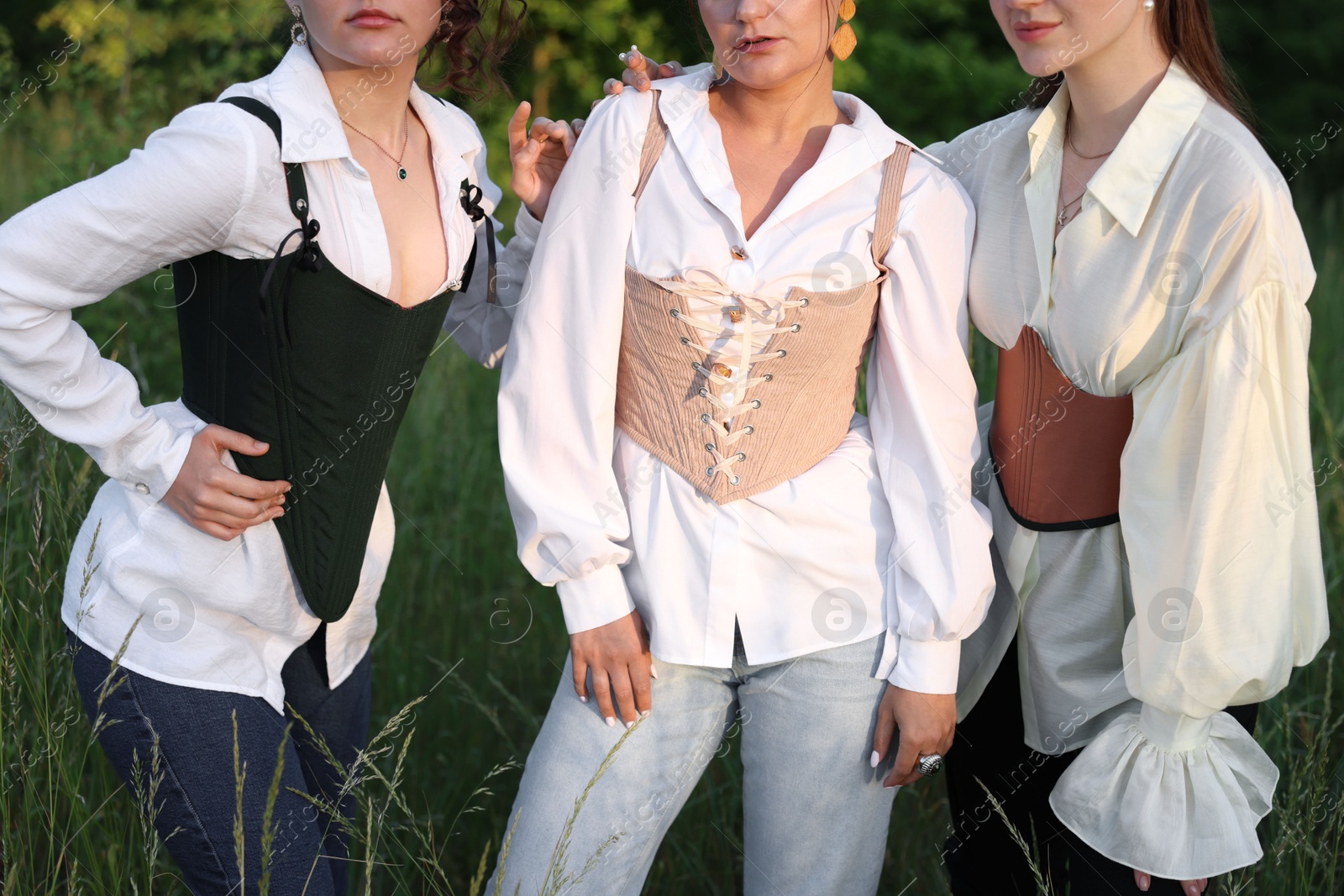 Photo of Women in stylish corsets posing outdoors, closeup