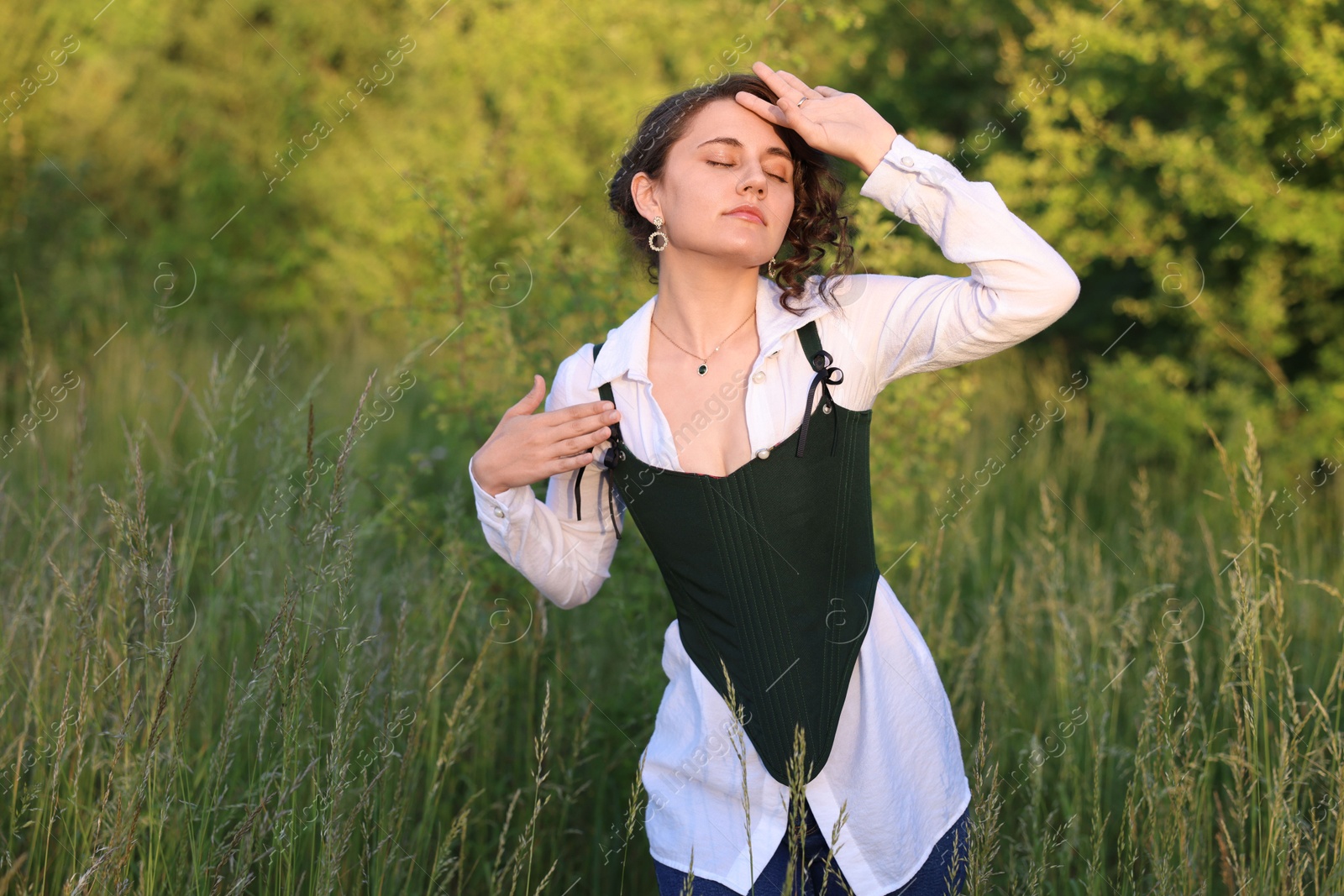 Photo of Beautiful woman in black corset posing outdoors