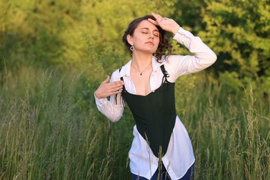 Photo of Beautiful woman in black corset posing outdoors