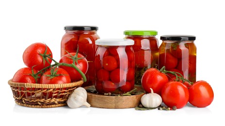 Tasty pickled tomatoes in jars, spices and vegetables isolated on white