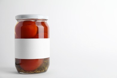 Photo of Tasty pickled tomatoes in jar on light background. Space for text