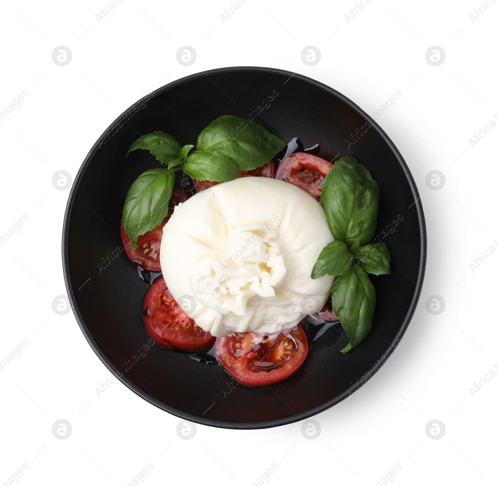 Photo of Delicious burrata cheese, tomatoes and basil in bowl isolated on white, top view