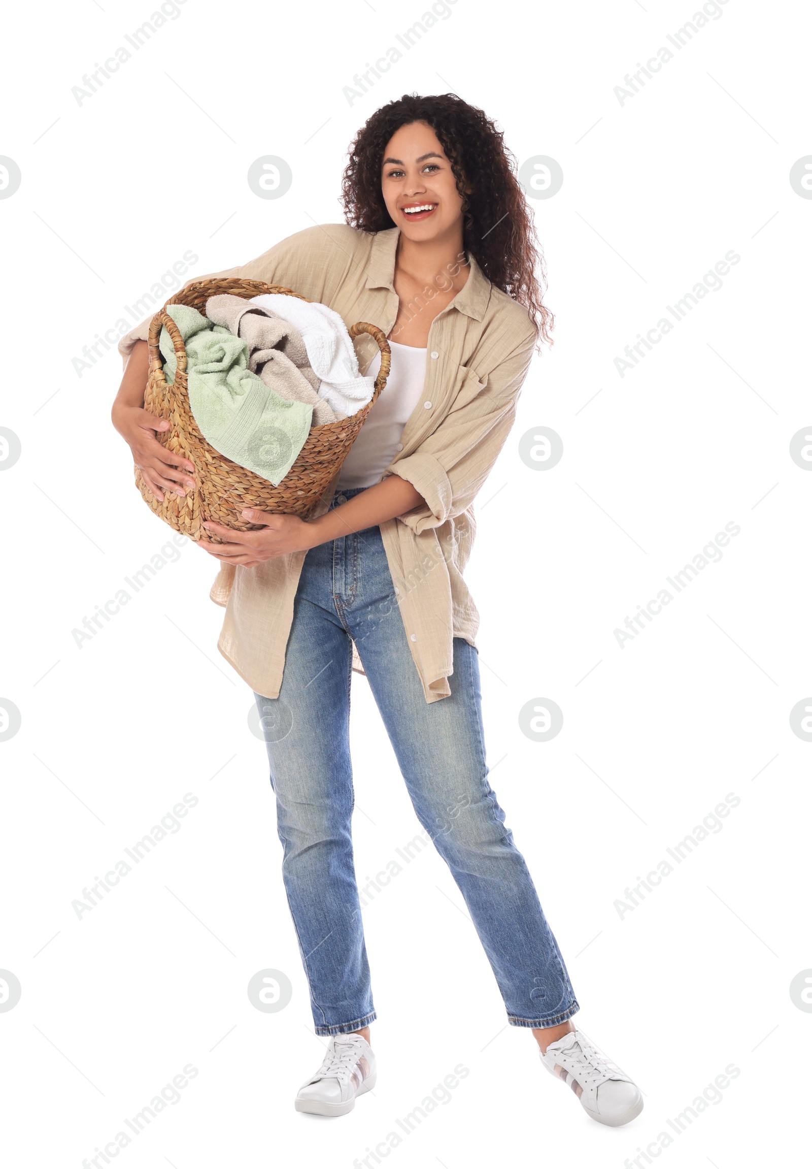 Photo of Happy woman with basket full of laundry on white background