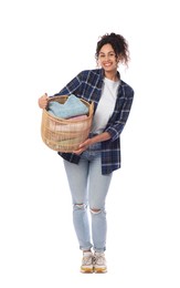 Happy woman with basket full of laundry on white background