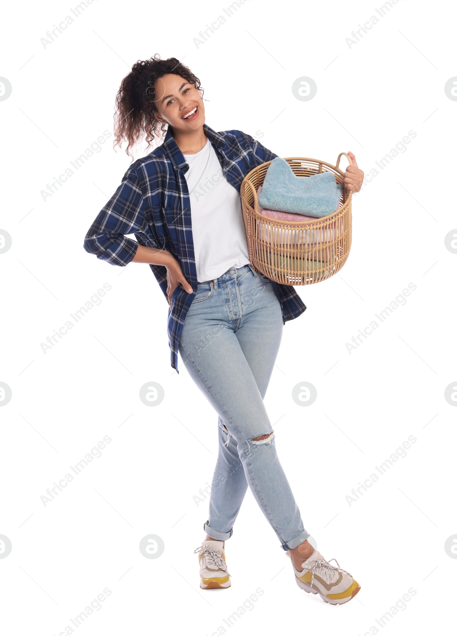 Photo of Happy woman with basket full of laundry on white background