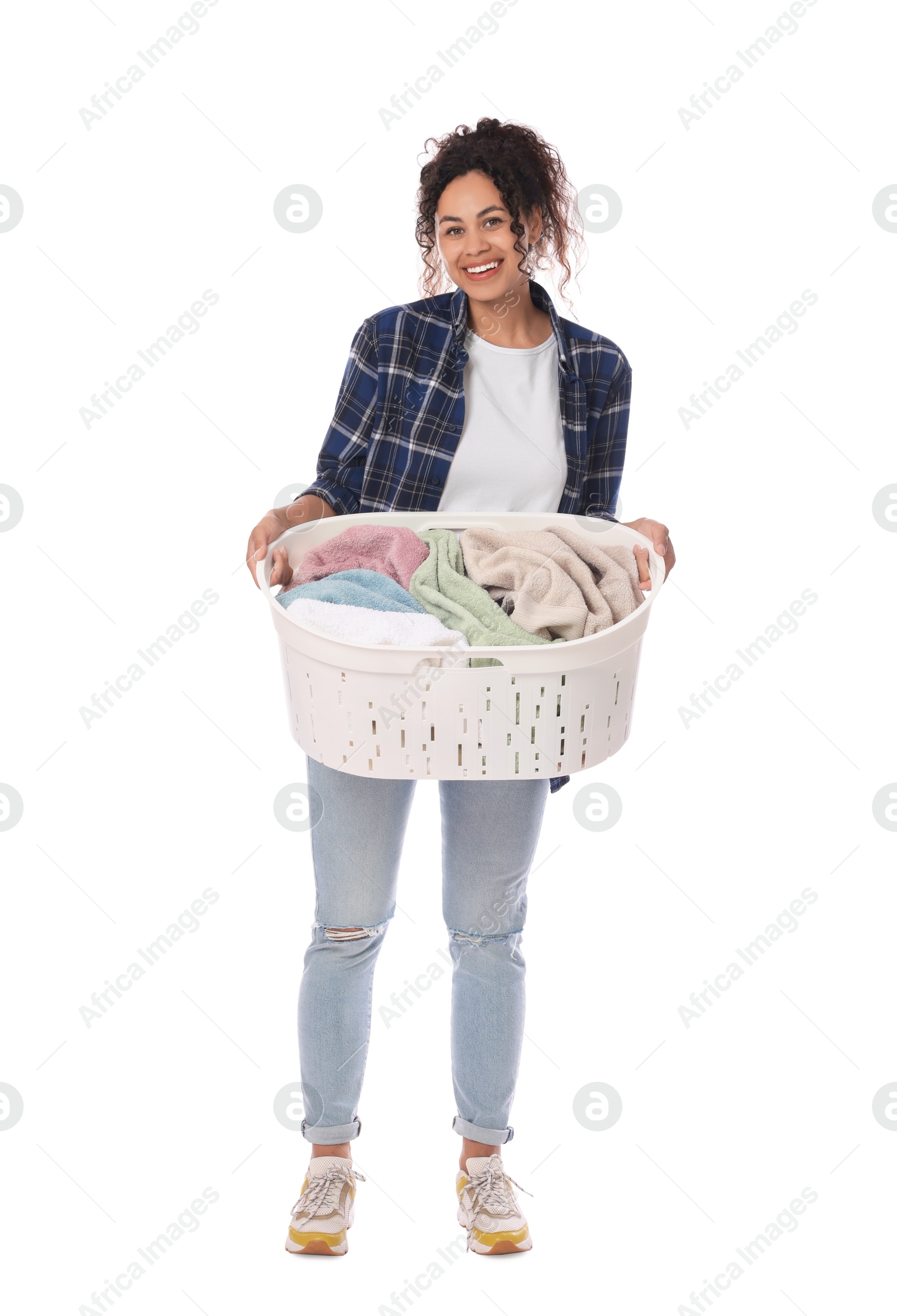 Photo of Happy woman with basket full of laundry on white background