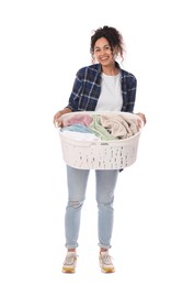 Happy woman with basket full of laundry on white background