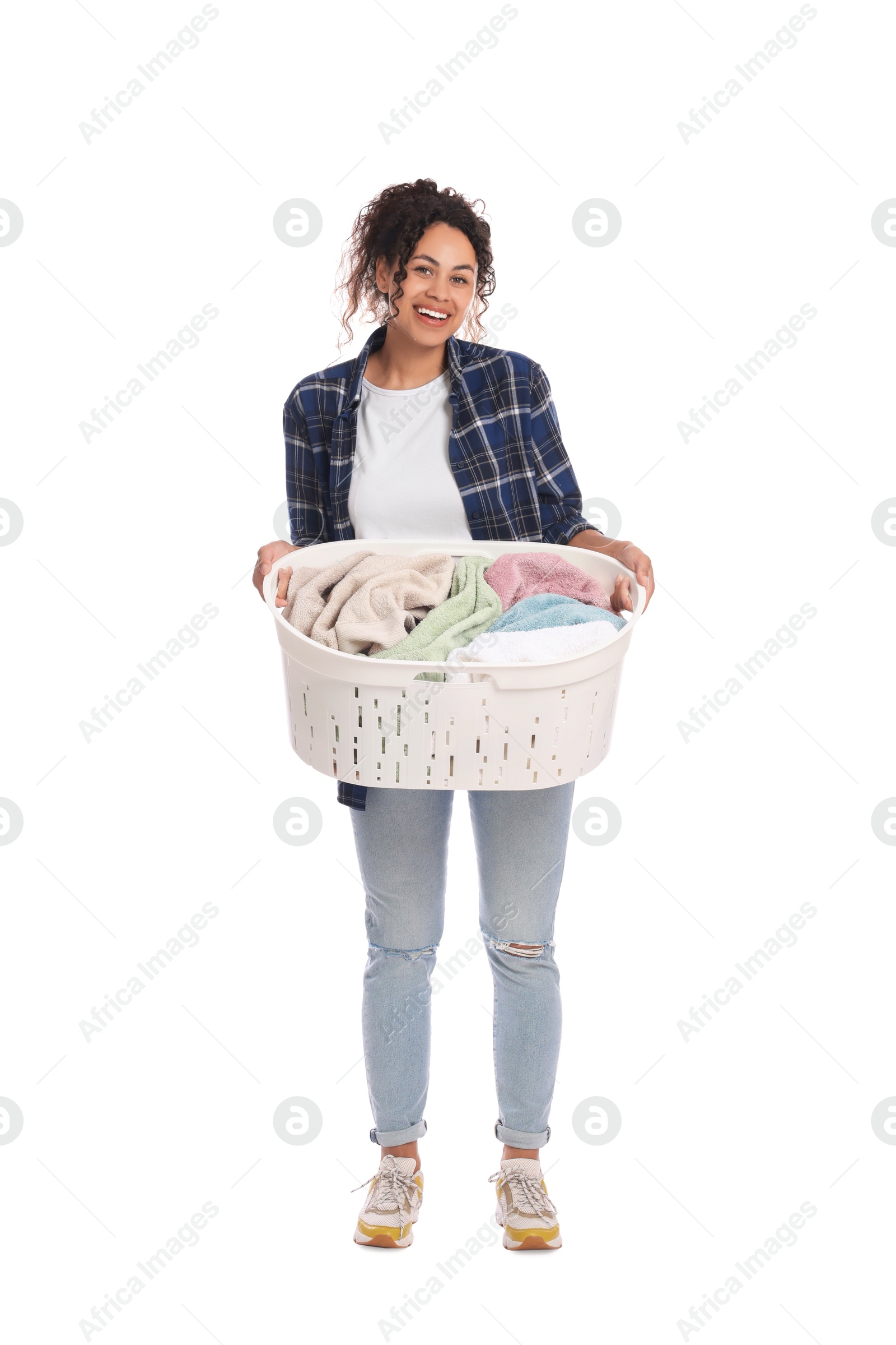 Photo of Happy woman with basket full of laundry on white background