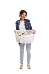 Happy woman with basket full of laundry on white background