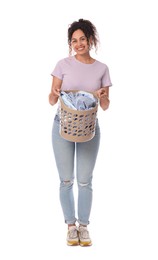 Happy woman with basket full of laundry on white background