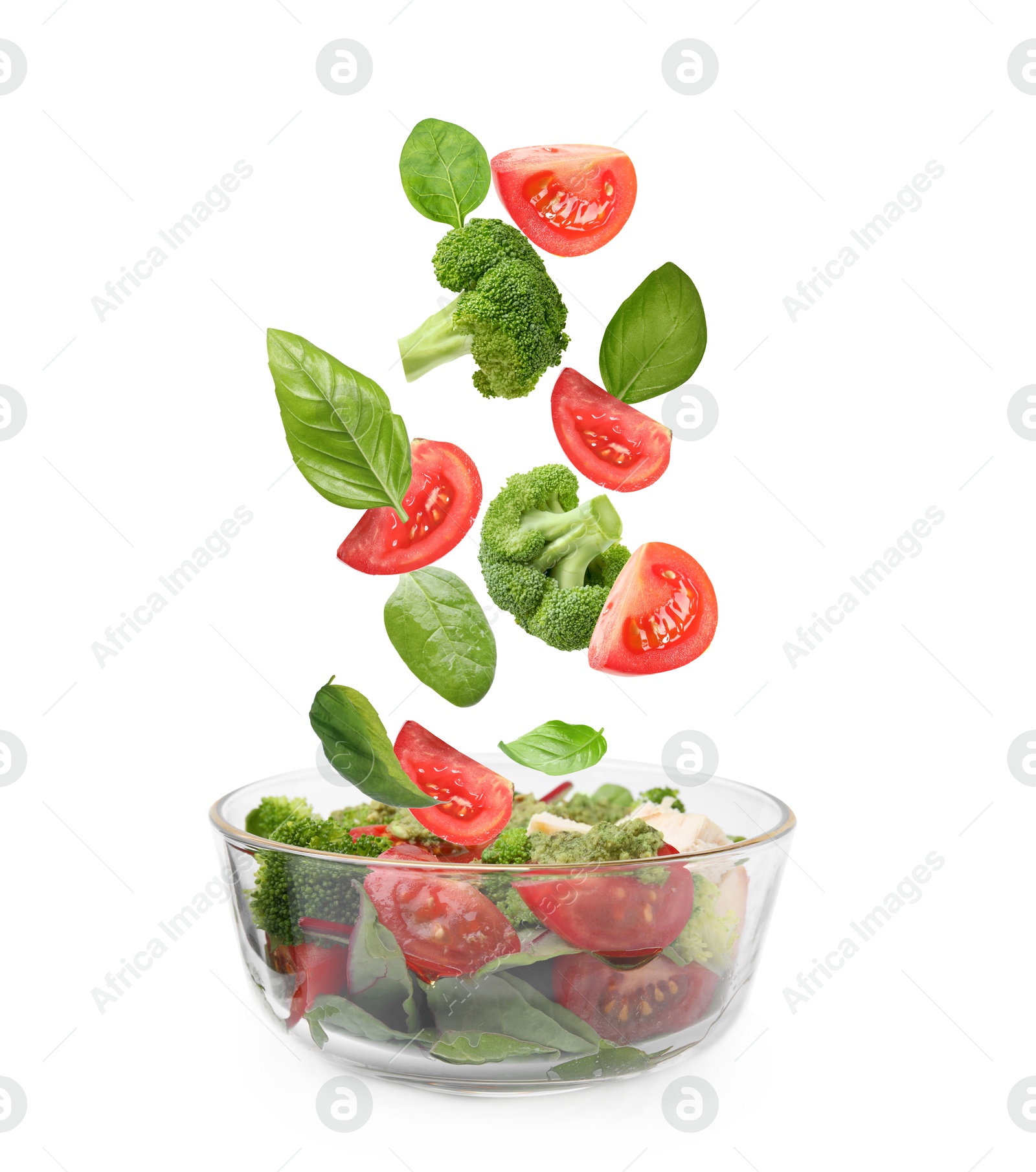 Image of Fresh vegetables for salad falling into bowl on white background