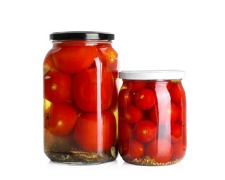 Photo of Tasty pickled tomatoes in jars isolated on white