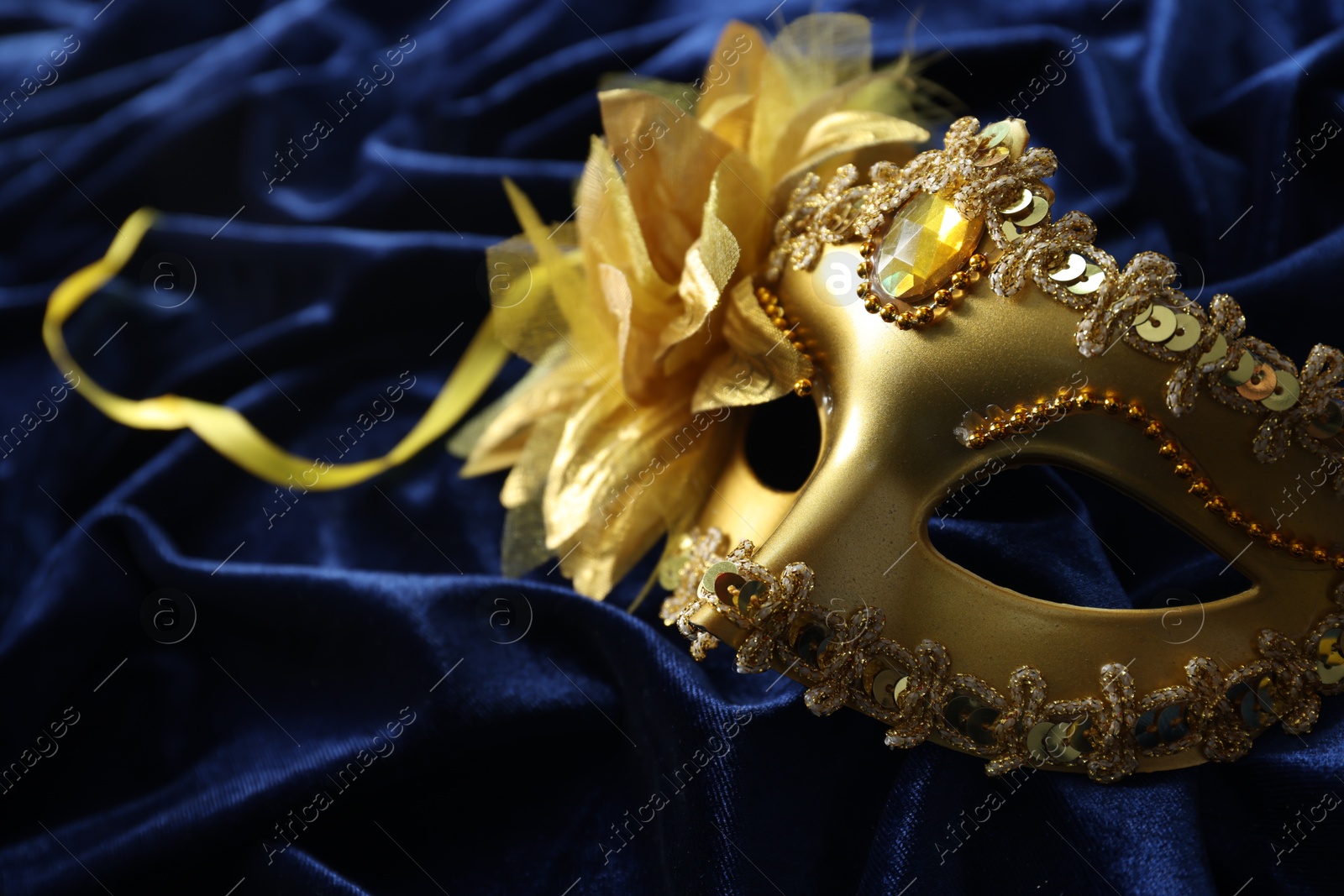 Photo of One beautiful carnival mask on blue fabric