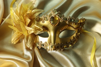 One beautiful carnival mask on golden fabric, top view