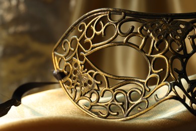 One beautiful carnival mask on golden fabric, closeup