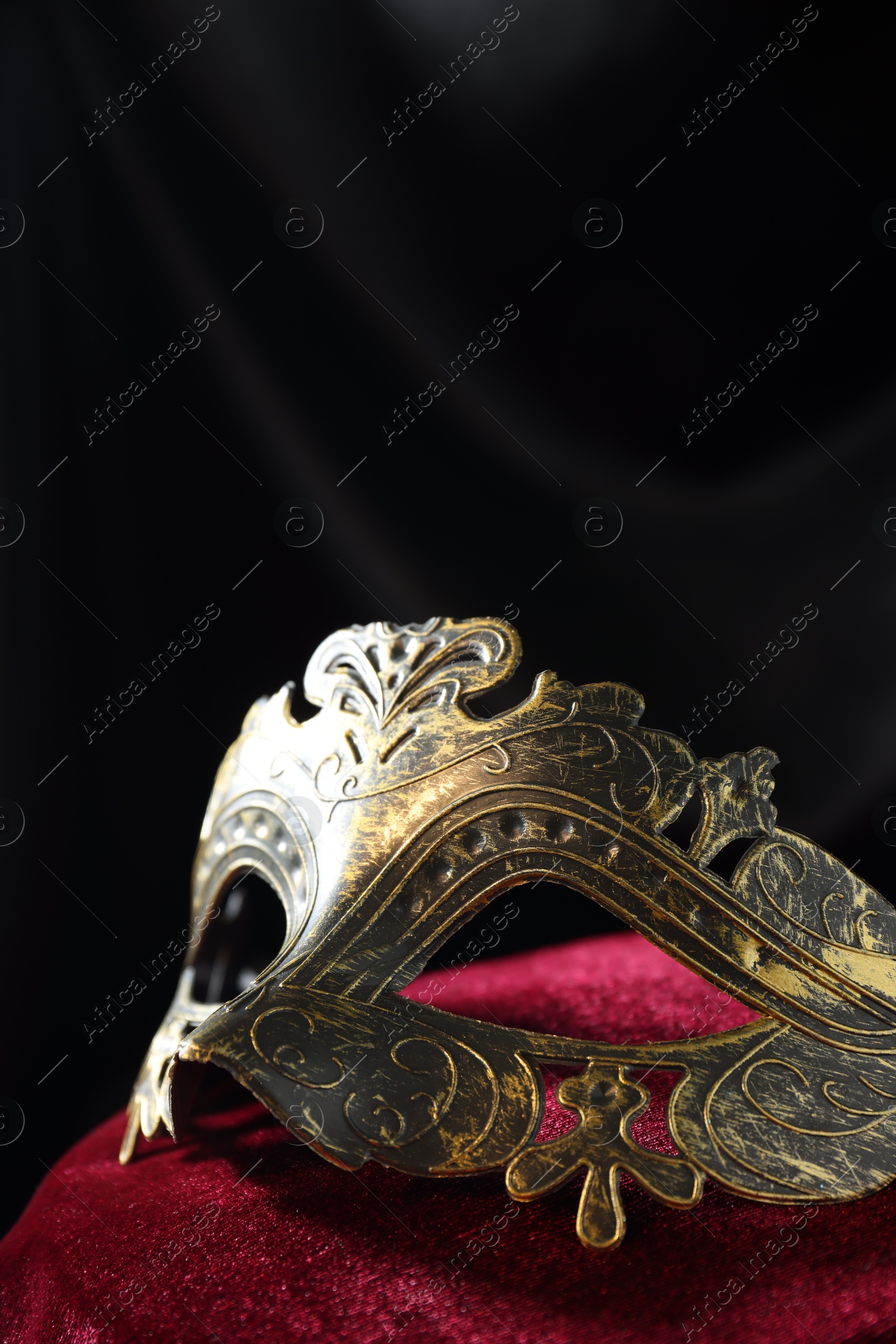 Photo of One beautiful carnival mask on red fabric, closeup