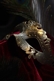 One beautiful carnival mask on red fabric, closeup