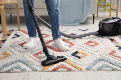 Photo of Man with vacuum cleaning carpet indoors, closeup