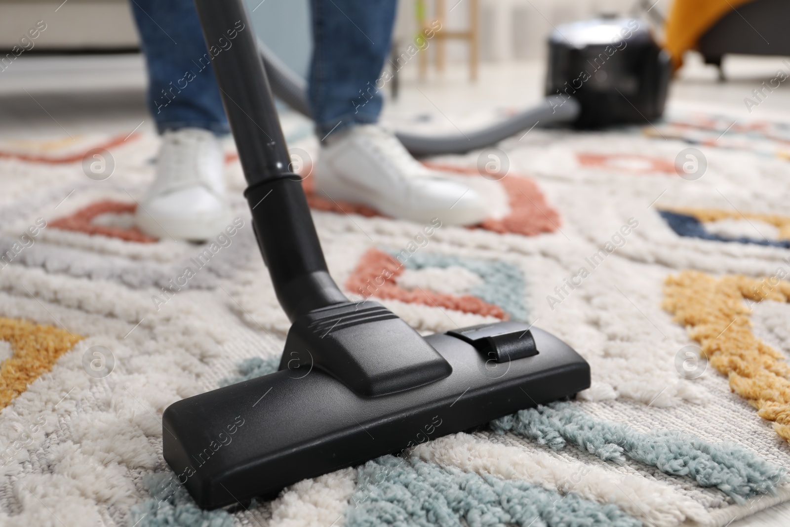 Photo of Man with vacuum cleaning carpet indoors, closeup